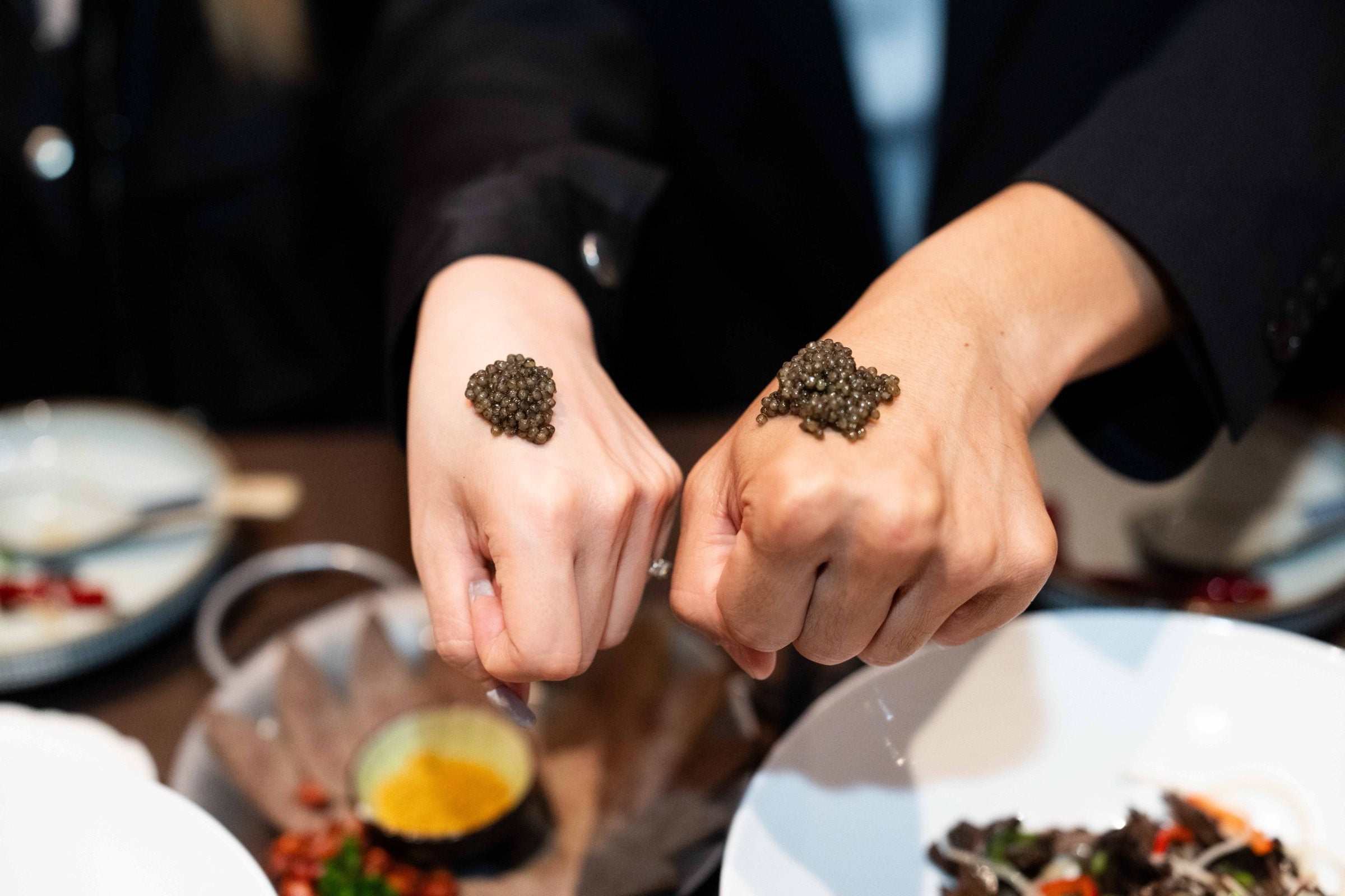 A bump of HOMĀ caviar served on the back of the hand